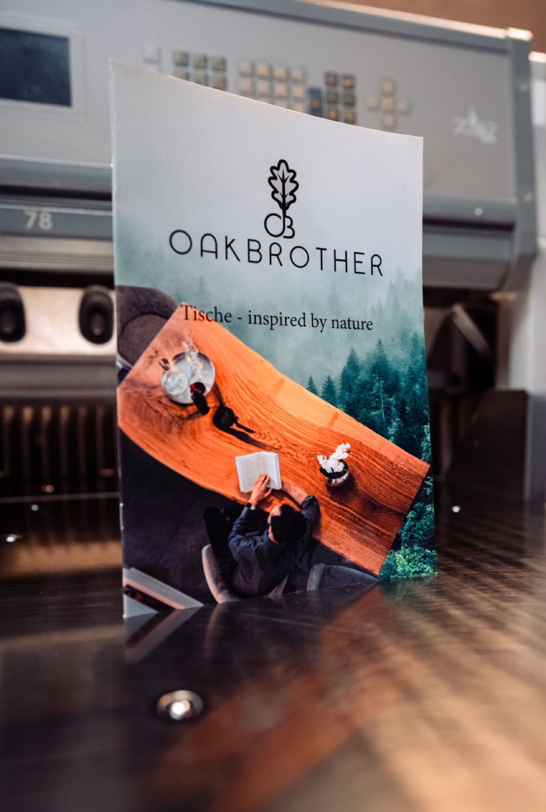 Gedruckter Oakbrother-Tischkatalog von Druckerei Block, fotografiert an einem Holztisch